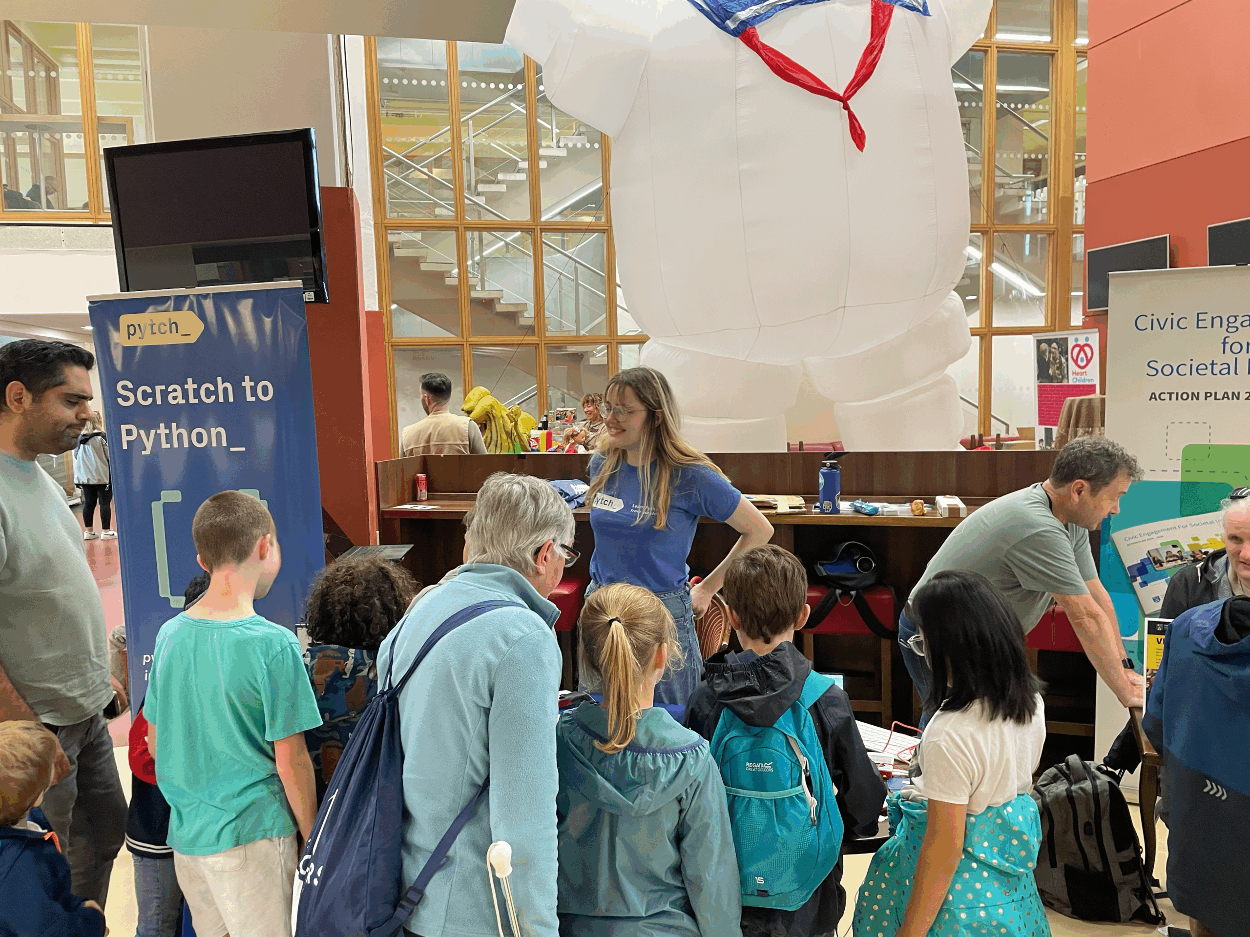 Maeve and Glenn at the Dublin Maker Pytch stand surrounded by kids and teachers playing games