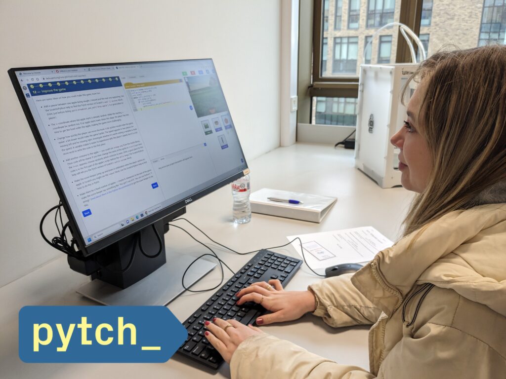 Photo showing a smiling student working with Pytch on a tutorial in the new script-by-script editor version. The Pytch logo is also visible at the bottom left hand corner.